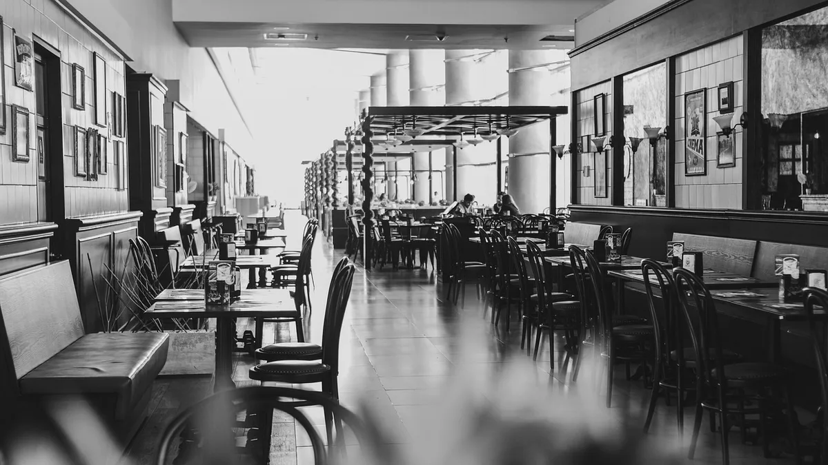 Bright modern restaurant dining room with empty tables during the day