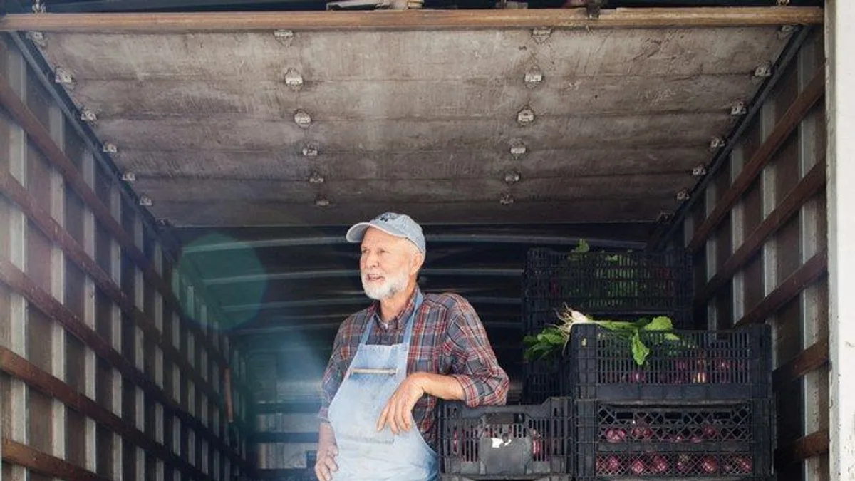 Produce delivery being unloaded from the back of a delivery truck