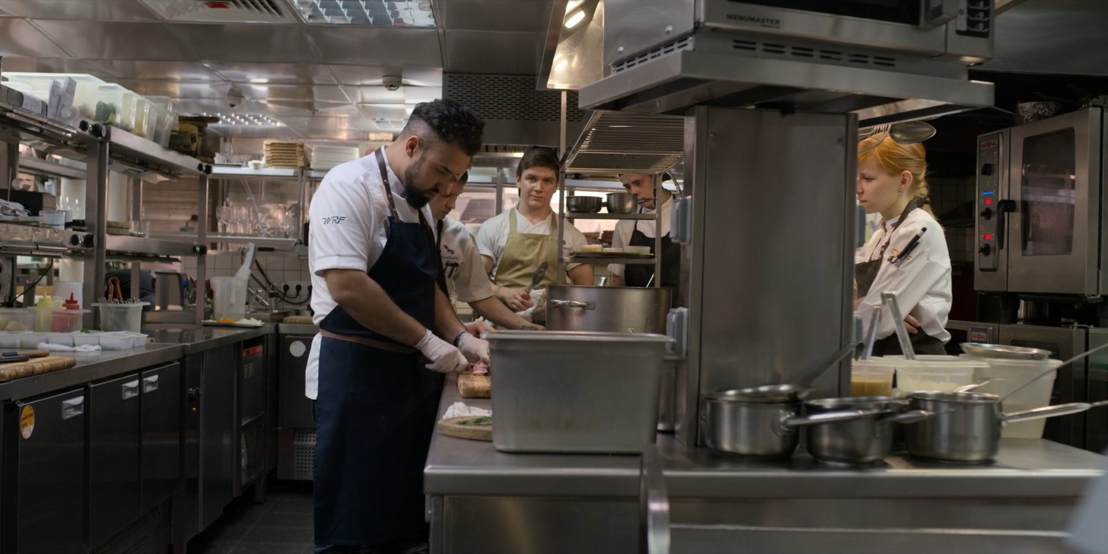A busy kitchen brigade working the line during a dinner service.