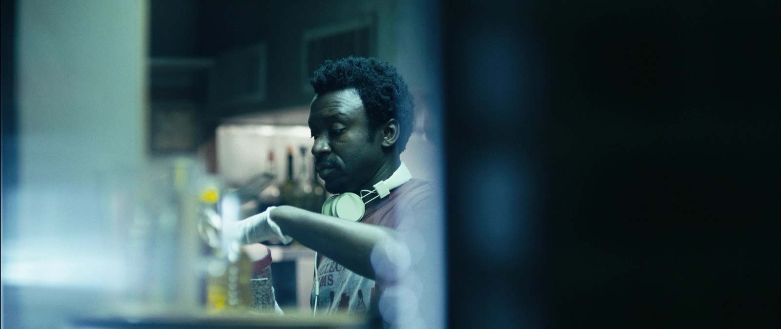 A restaurant worker prepping behind a dimly lit bar counter.